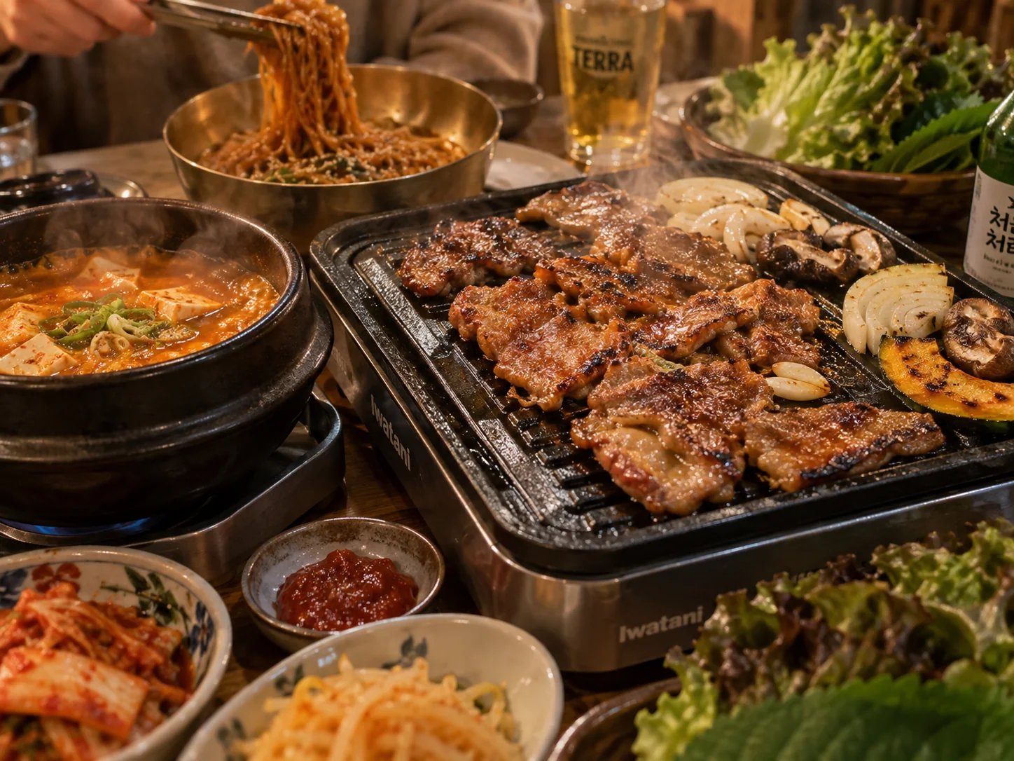 Nærbillede af koreansk grill med grillede stykker kød, suppe og nudler